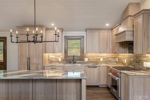 kitchen with light brown cabinetry, custom exhaust hood, hanging light fixtures, stainless steel range, and light stone countertops