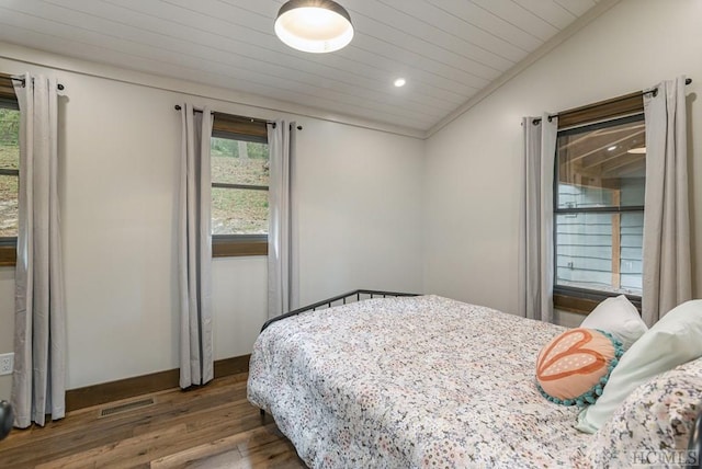 bedroom featuring dark wood-type flooring and vaulted ceiling