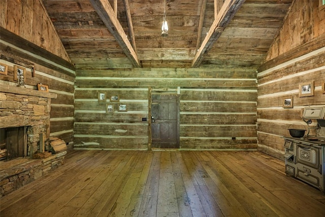 interior space featuring lofted ceiling, wooden walls, dark hardwood / wood-style floors, and a fireplace