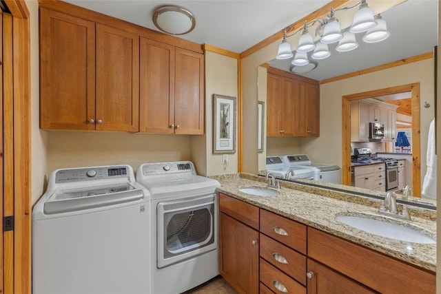 laundry room with crown molding, washing machine and dryer, and sink