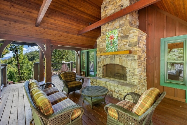 interior space featuring vaulted ceiling with beams, an outdoor stone fireplace, and wooden ceiling