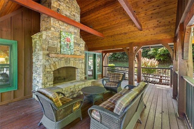 wooden deck featuring ceiling fan and an outdoor stone fireplace