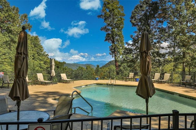 view of pool featuring a mountain view and a patio area