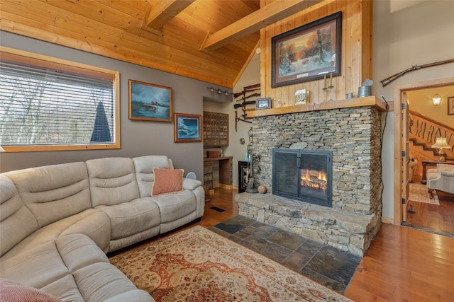 living room featuring wood ceiling, a stone fireplace, vaulted ceiling with beams, and wood-type flooring