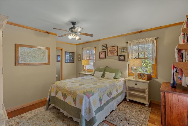 bedroom with light hardwood / wood-style floors, crown molding, and ceiling fan