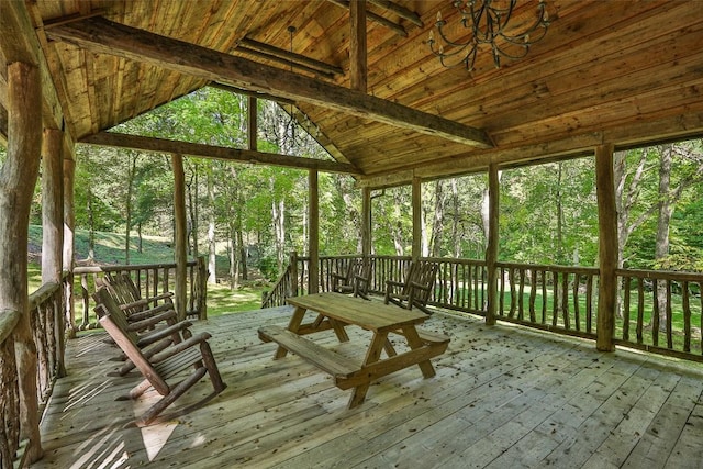 unfurnished sunroom featuring vaulted ceiling with beams