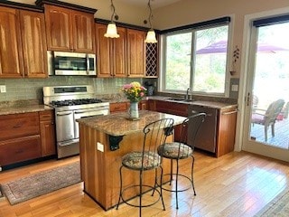 135 Whisper Lake Dr, Sapphire, NC 28774 - kitchen featuring stainless steel appliances, light wood-style flooring, a center island, and a breakfast bar area