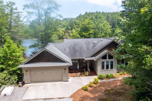 135 Whisper Lake Dr, Sapphire, NC 28774 - view of front of house featuring driveway, an attached garage, a view of trees, and a water view