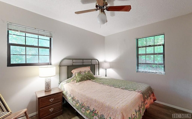 bedroom featuring a textured ceiling, dark hardwood / wood-style floors, and ceiling fan