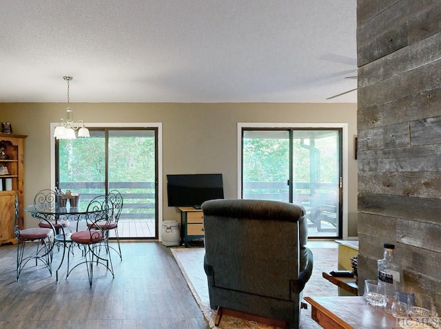 interior space with ceiling fan with notable chandelier, wood-type flooring, and a textured ceiling