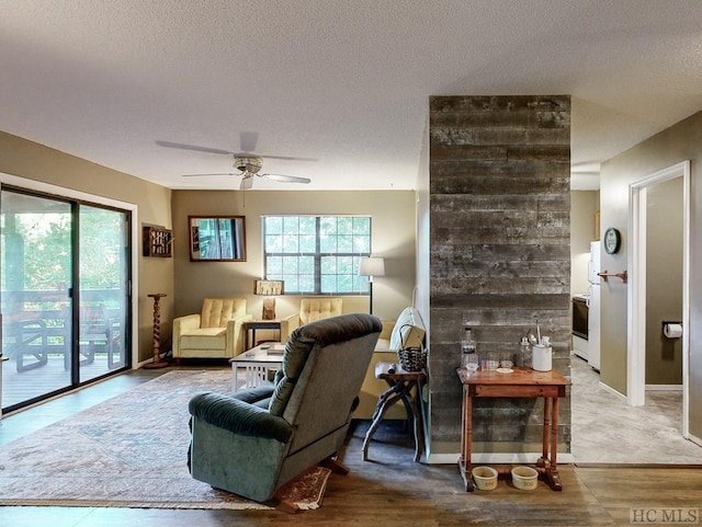 living room with a textured ceiling and ceiling fan