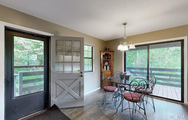 dining space with dark hardwood / wood-style flooring, a chandelier, a textured ceiling, and a wealth of natural light