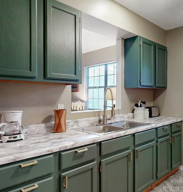 kitchen with sink, a textured ceiling, and green cabinetry