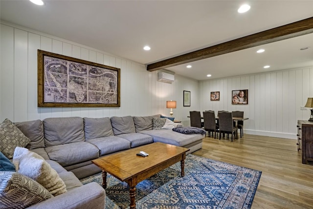 49 Lakeside Fls, Cullowhee, NC 28723 - living room featuring light wood finished floors, a wall mounted air conditioner, a decorative wall, and beamed ceiling