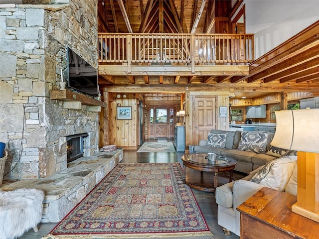 399 Toxaway Ct, Lake Toxaway, NC 28747 - living room featuring a stone fireplace, a towering ceiling, wood-type flooring, and wooden walls