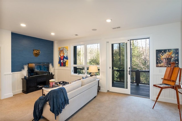 living room with recessed lighting, wainscoting, visible vents, and light carpet