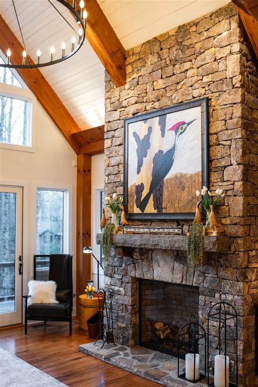 living room with a fireplace, lofted ceiling with beams, and wood finished floors