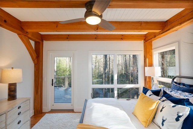 bedroom featuring beam ceiling and access to outside