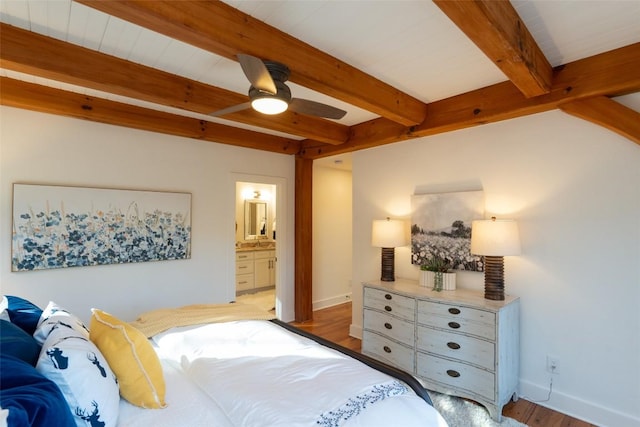 bedroom featuring beamed ceiling, connected bathroom, baseboards, and wood finished floors