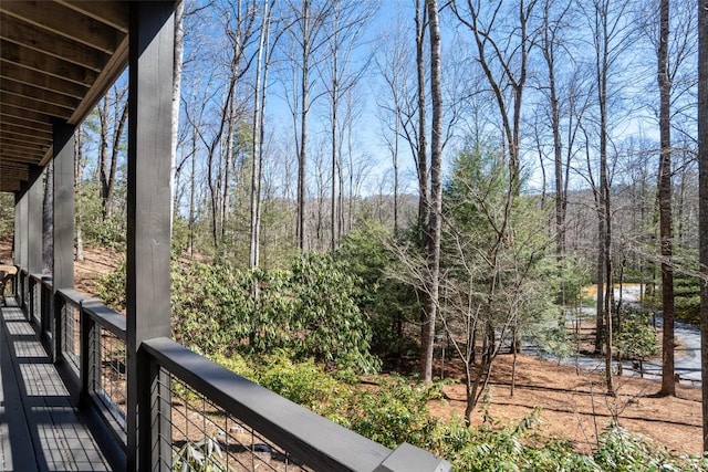 balcony featuring a forest view