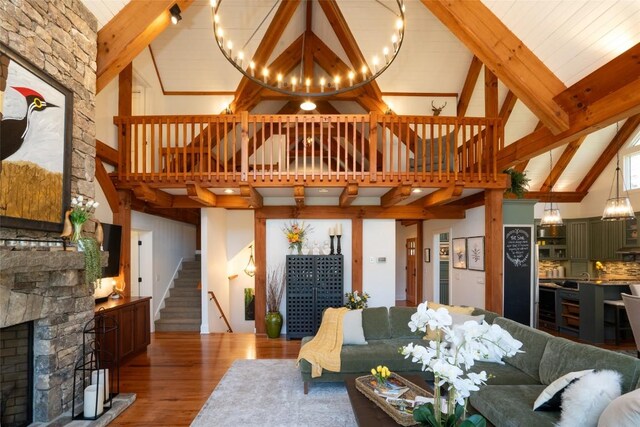 living area featuring beam ceiling, plenty of natural light, and wood finished floors