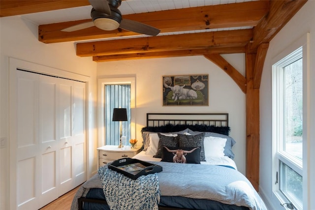 bedroom with a closet, beamed ceiling, and multiple windows