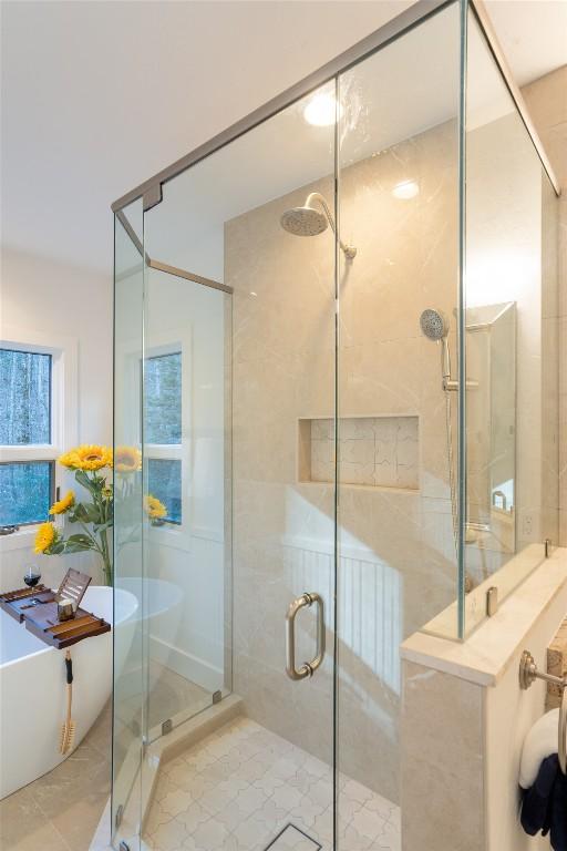 bathroom with tile patterned floors, a stall shower, and a freestanding bath