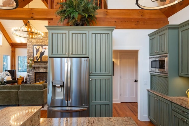 kitchen with a chandelier, vaulted ceiling with beams, stainless steel appliances, and green cabinetry