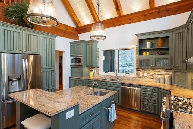 kitchen featuring beamed ceiling, stainless steel appliances, green cabinets, and a sink