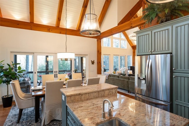 dining space featuring french doors, beam ceiling, high vaulted ceiling, and wood finished floors