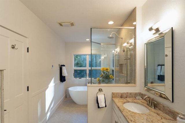 full bathroom featuring visible vents, recessed lighting, a stall shower, a freestanding tub, and vanity