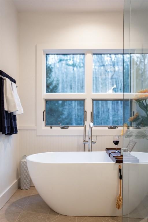 full bath featuring tile patterned floors and a soaking tub