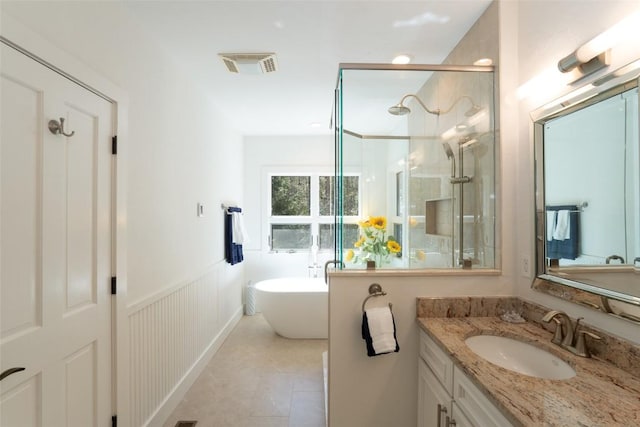 bathroom featuring visible vents, wainscoting, a shower stall, a freestanding bath, and vanity