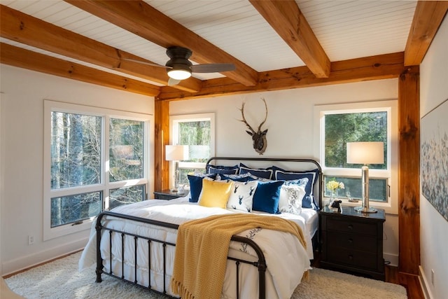 bedroom featuring beamed ceiling, baseboards, and wood finished floors