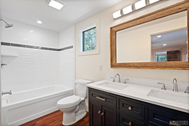 full bathroom with tiled shower / bath combo, wood-type flooring, vanity, and toilet