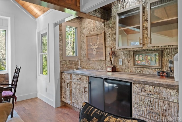 bar with refrigerator, lofted ceiling, hardwood / wood-style flooring, wood ceiling, and sink