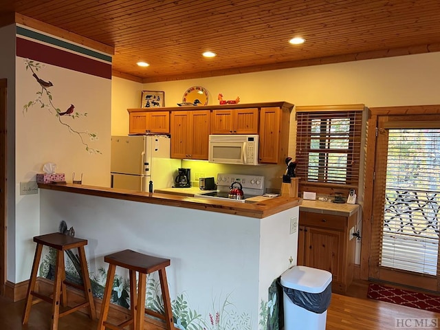 35-B Portland Rdg Unit B, Cashiers, NC 28717 - kitchen with white appliances, wood ceiling, a kitchen breakfast bar, wood finished floors, and brown cabinetry