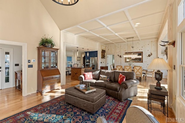 living room with light hardwood / wood-style floors and coffered ceiling