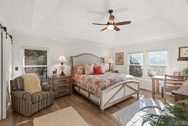 bedroom featuring dark hardwood / wood-style flooring, ceiling fan, crown molding, a barn door, and wooden ceiling