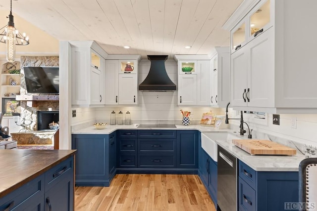 kitchen with white cabinets, hanging light fixtures, blue cabinetry, and custom range hood