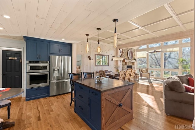 kitchen with light hardwood / wood-style flooring, blue cabinets, decorative light fixtures, stainless steel appliances, and wooden ceiling