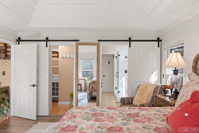 bedroom with crown molding, a barn door, and wooden ceiling