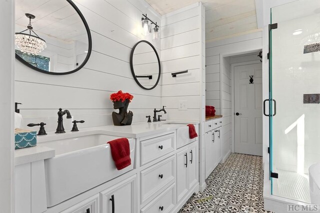 bathroom with an enclosed shower, vanity, and wood walls