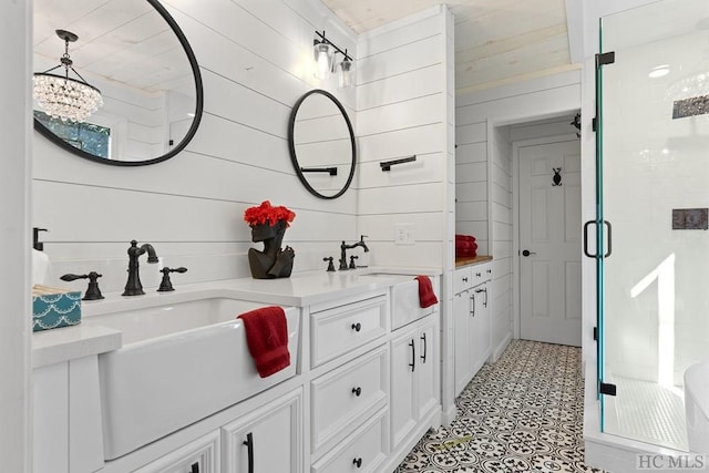 bathroom featuring vanity, a shower with door, and wood walls