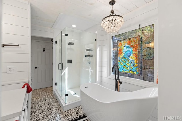 bathroom with vanity, independent shower and bath, and a chandelier