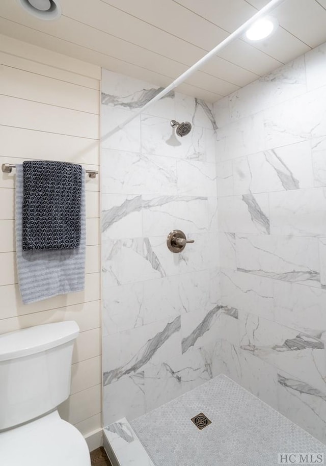 bathroom with tiled shower and toilet