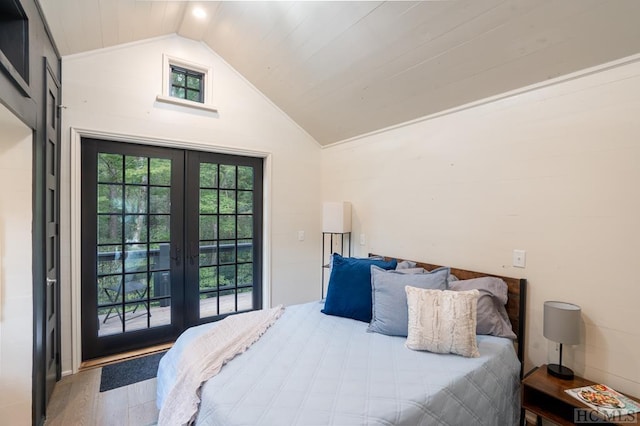 bedroom featuring hardwood / wood-style floors, vaulted ceiling, french doors, and access to outside