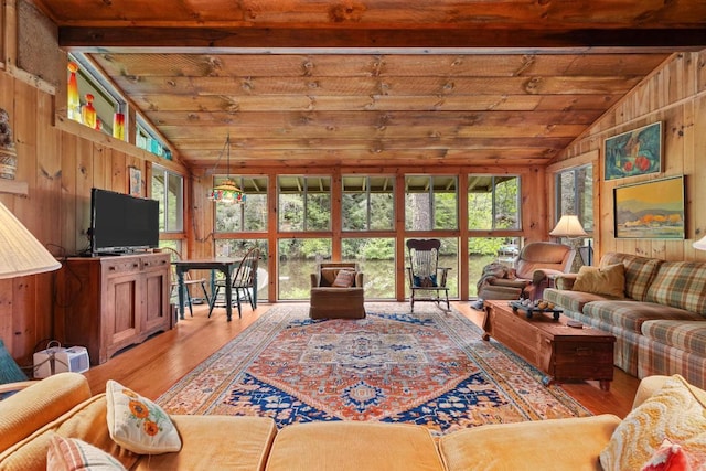 living area featuring light wood finished floors, wooden ceiling, and wood walls
