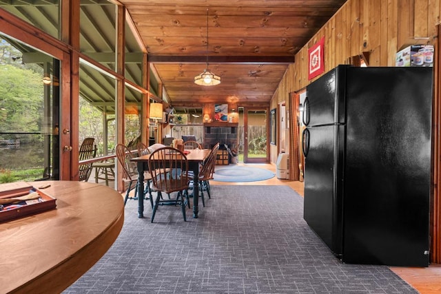 dining space with healthy amount of natural light, wooden walls, vaulted ceiling, and wooden ceiling