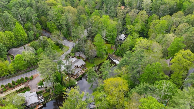 drone / aerial view of a large body of water and a heavily wooded area